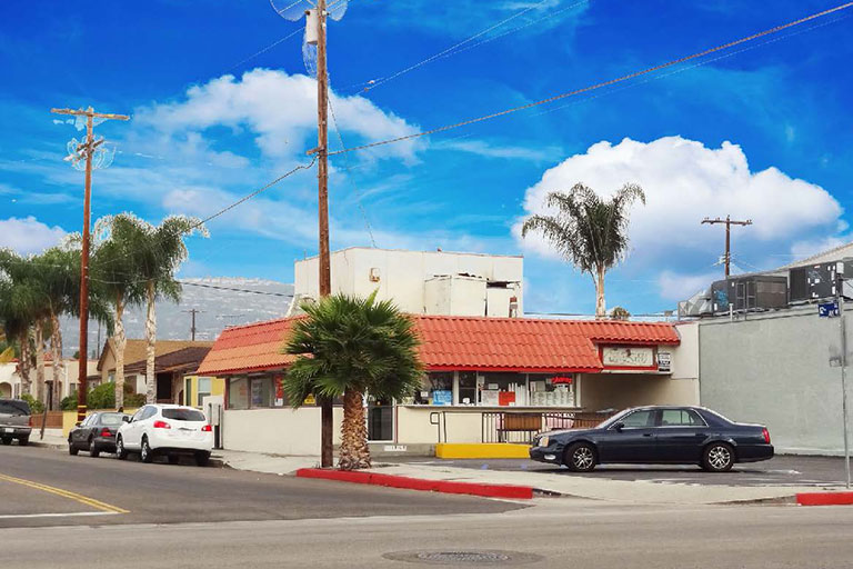 Small building with red roof and cars.