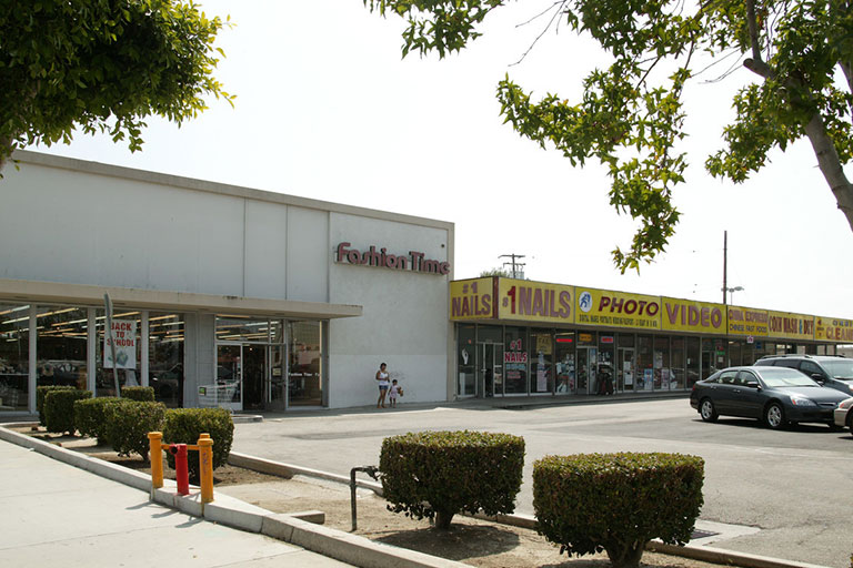Shopping plaza with fashion and nail stores.