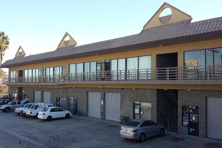 Commercial building with parked cars outside.