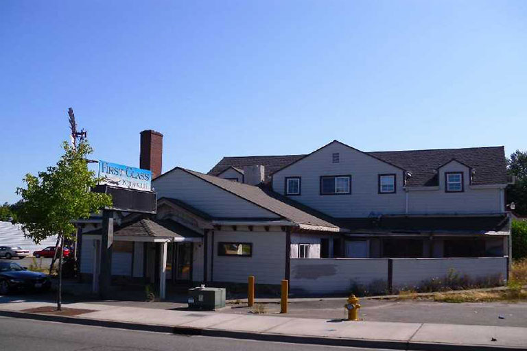 White building with a blue sign outside.