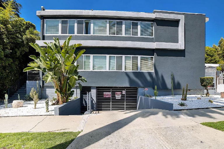 Modern building with cactus and palm landscaping.