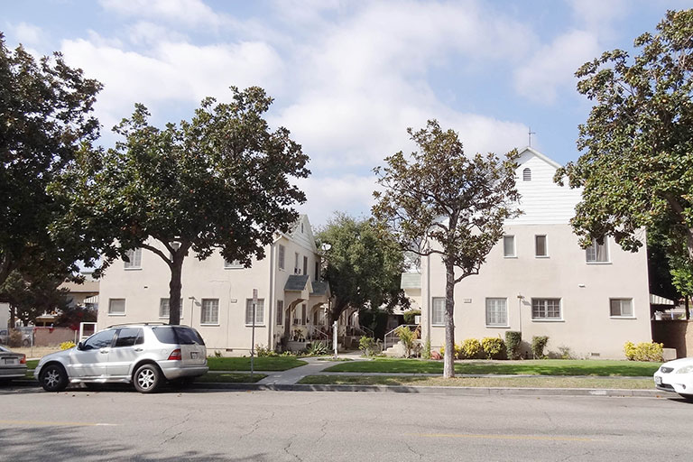 Street view of beige residential buildings.