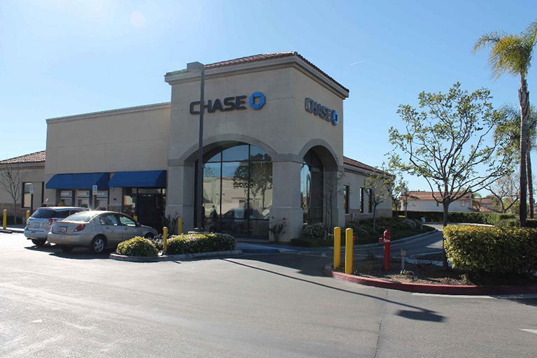 Bank building with cars in parking lot.
