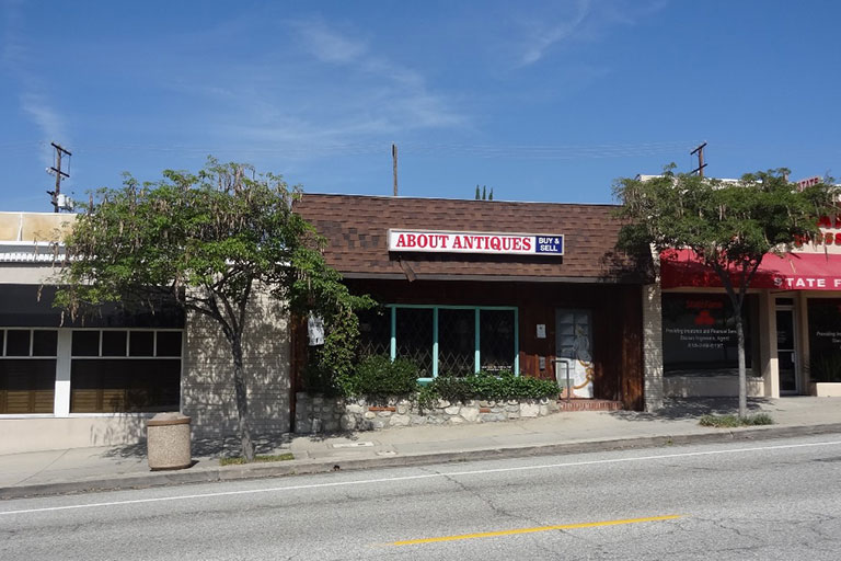 Antique store exterior with trees and signage.