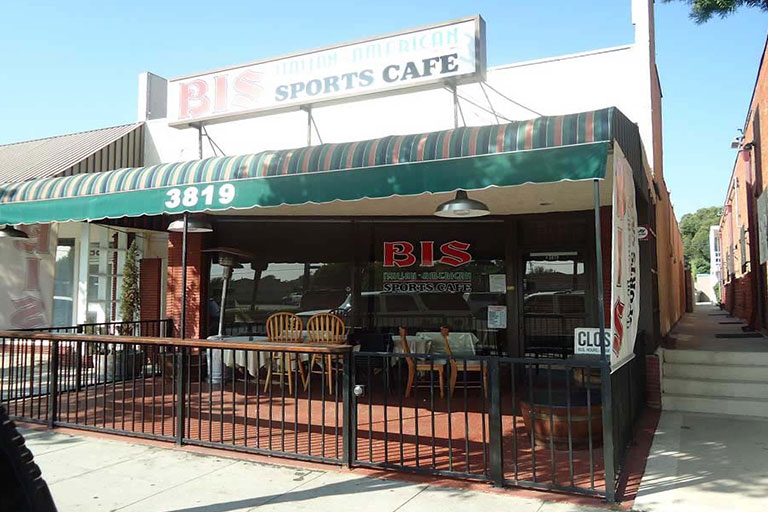 Sports cafe with outdoor seating and awning.