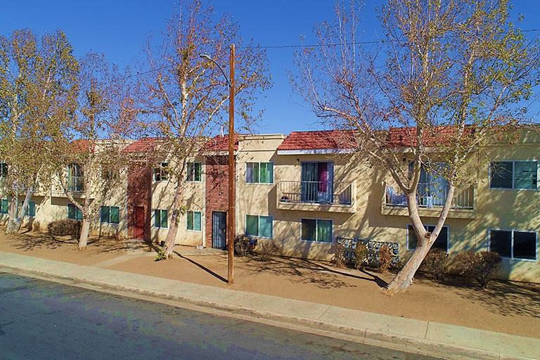 Two-story apartment building with trees outside.