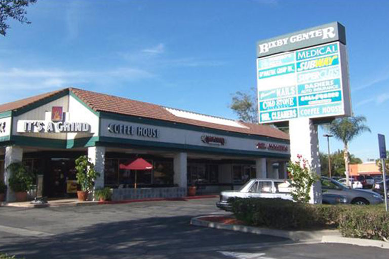 Shopping center with various store signs visible.