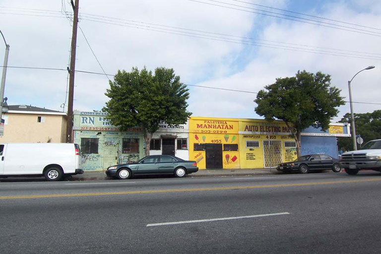 Street view with parked cars and buildings.