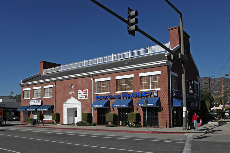 Brick building with pharmacy on street corner.