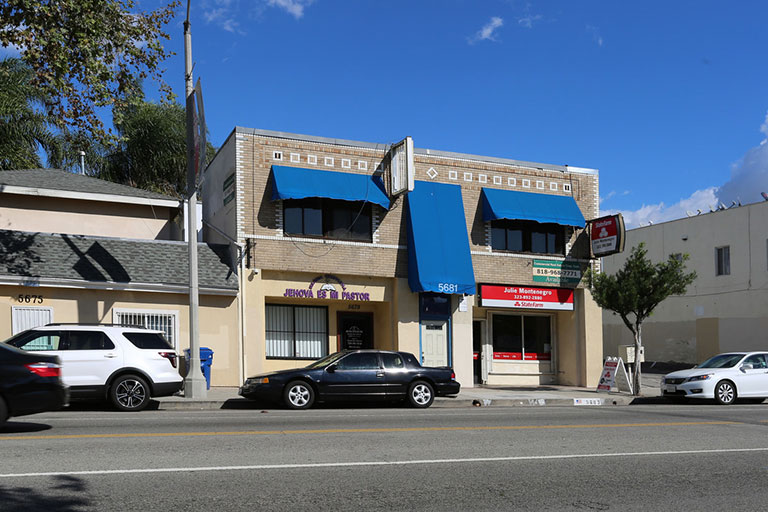 Street view of building with blue awnings.
