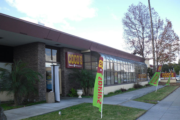 Restaurant exterior with colorful flags outside.
