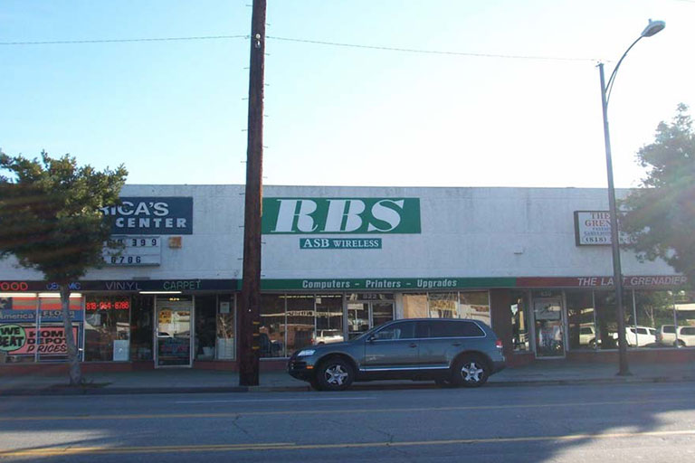 Street view of shops with parked car.