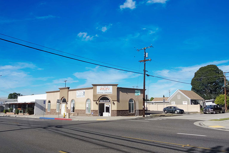 Street view of a building under blue sky.
