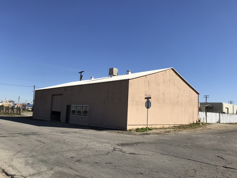 Beige warehouse on empty street corner.