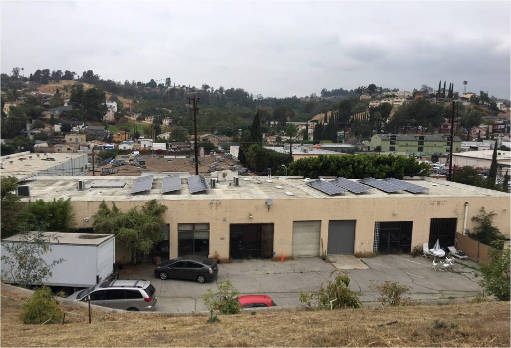 Industrial building with solar panels and cars.