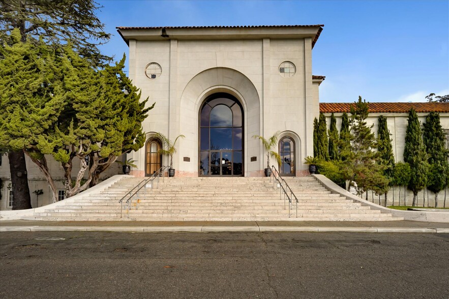 Elegant building with arched entrance and steps.