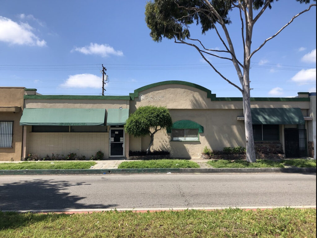 Single-story building with green awnings.