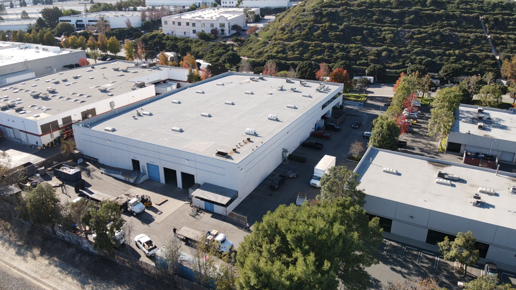 Aerial view of industrial warehouse and greenery.