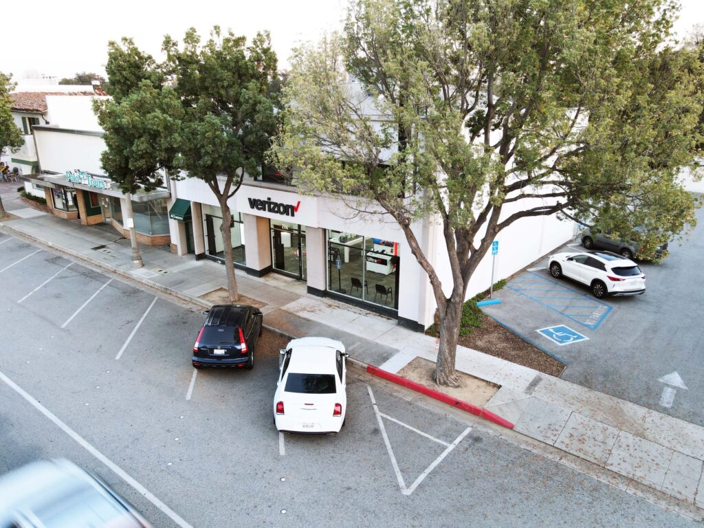 Street view with parked cars and trees.