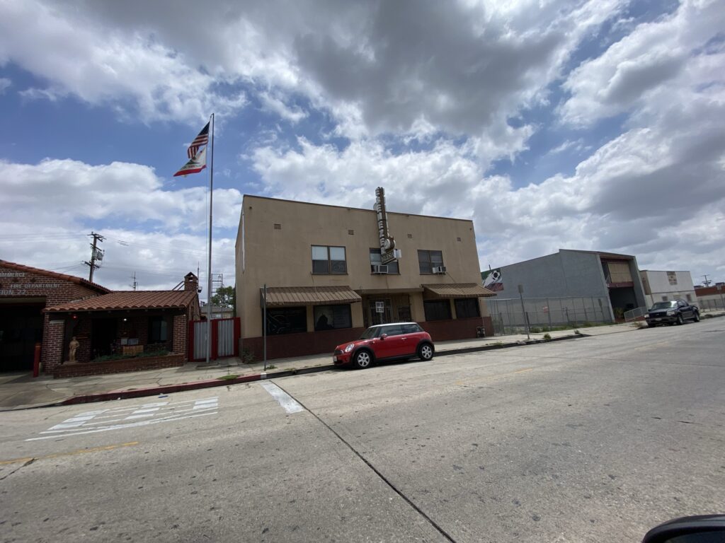 Building with overcast sky and parked car.